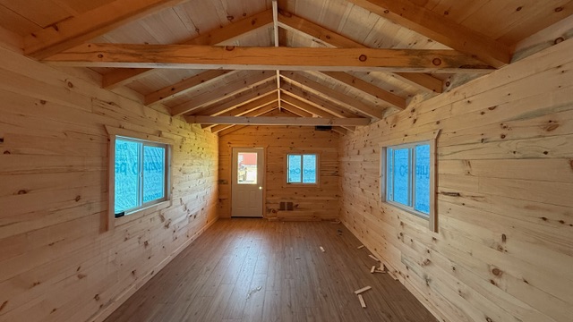 Pine cabin interior with vaulted ceiling and front door